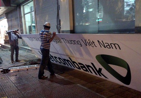 Việc thay đổi biển hiệu Vietcombank được thực hiện ráo riết trong những ngày cuối tuần. Ảnh: Anh Quân