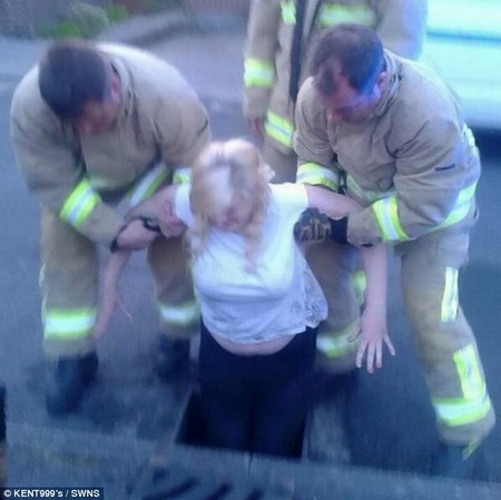 Các nhân viên cứu hộ giải cứu cô nữ sinh khỏi miệng cống