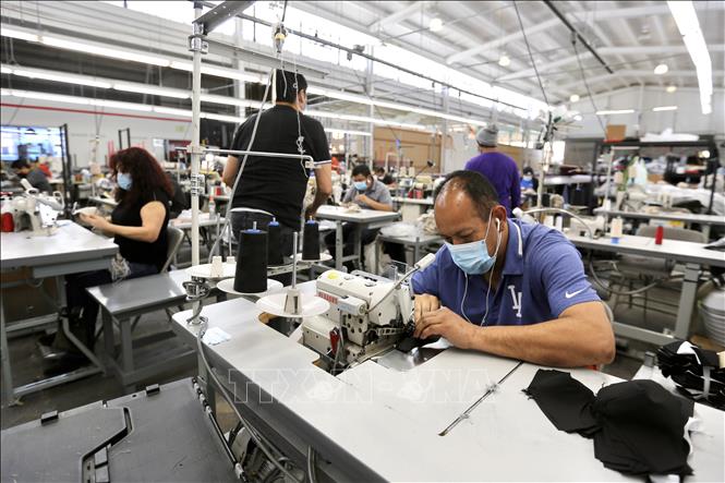 Công nhân làm việc tại nhà máy ở Vernon, Los Angeles, California, Mỹ ngày 16/4/2020. Ảnh: THX/TTXVN