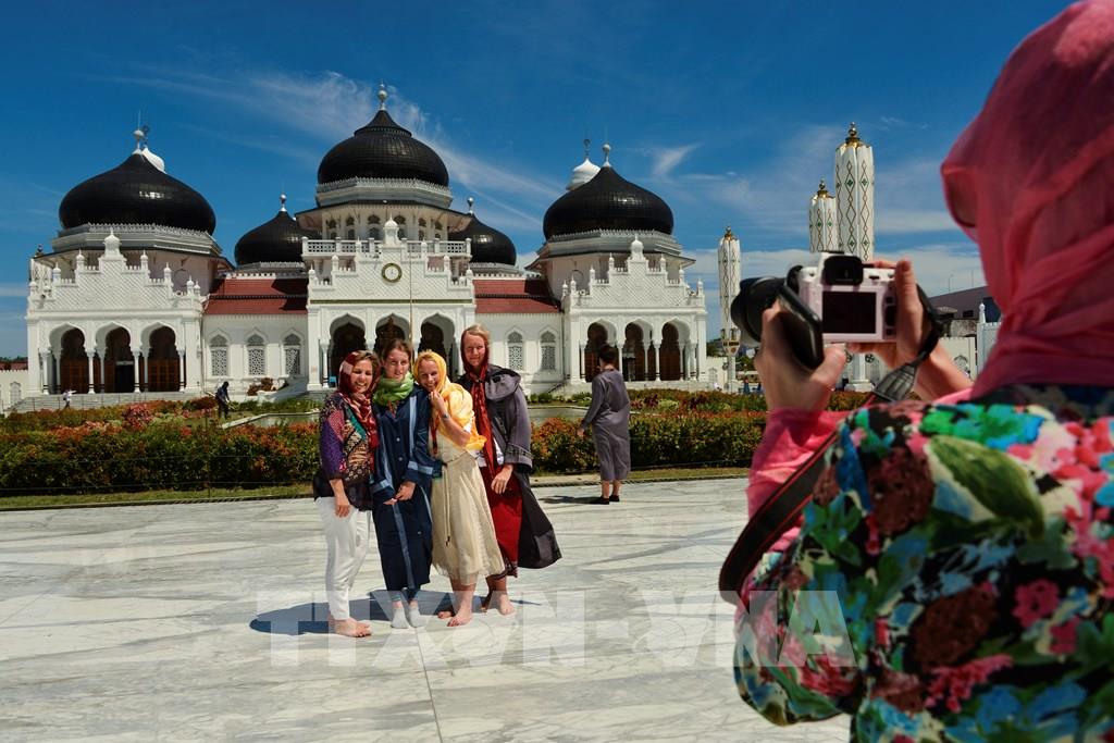 Khách du lịch nước ngoài thăm nhà thờ Hồi giáo Baiturrahman ở Banda Aceh, Indonesia. Ảnh: AFP/TTXVN