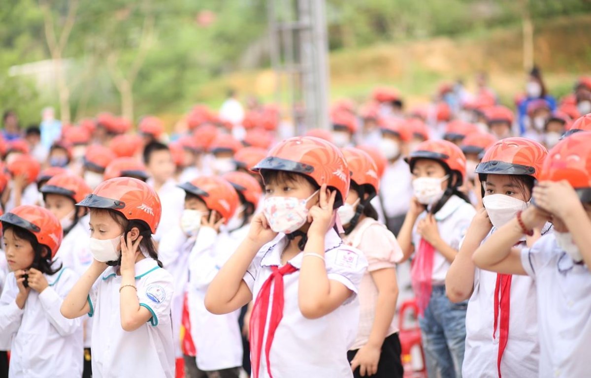 Học sinh tiểu học thực hành đội mũ bảo hiểm đạt chuẩn và đúng cách. (Ảnh: CTV/Vietnam+)