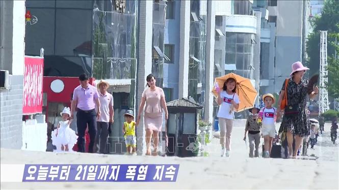 Người dân di chuyển trên một đường phố ở Triều Tiên dưới thời tiết nắng nóng gay gắt, ngày 20/7/2023. Ảnh: YONHAP/TTXVN
