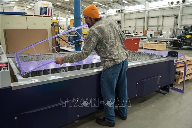 Công nhân làm việc bên trong một nhà máy ở Maryland, Mỹ. Ảnh: AFP/TTXVN