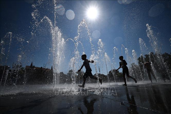 Trẻ em làm mát tại đài phun nước ở Colmar, miền Đông Pháp ngày 21/8/2023. Ảnh: AFP/TTXVN