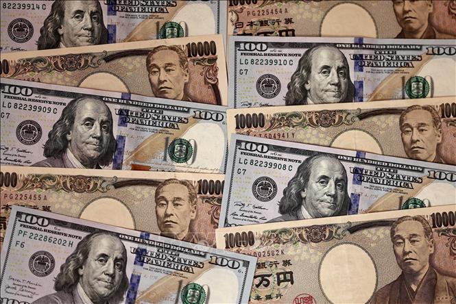 Tiền giấy mệnh giá 10.000 Yên và 100 USD tại Tokyo, Nhật Bản. Ảnh: AFP/TTXVN