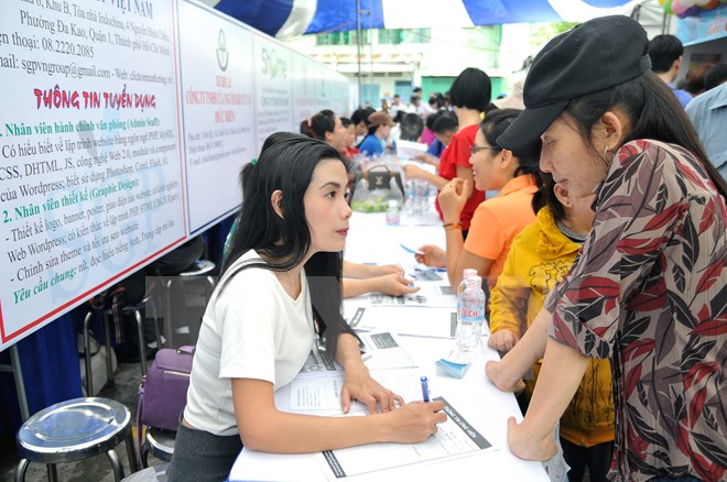 Hướng dẫn thủ tục đăng ký mẫu tìm việc cho người lao động tại một phiên giới thiệu việc làm ở Thành phố Hồ Chí Minh. Ảnh: An Hiếu/TTXVN