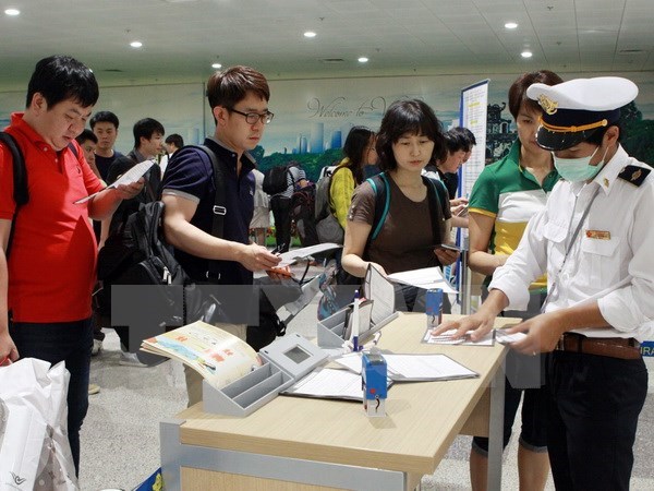 Hành khách từ Hàn Quốc nhập cảnh đến Việt Nam thực hiện kê khai tờ khai y tế. Ảnh: Dương Ngọc/TTXVN