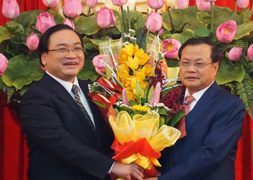  Nguyên Bí thư Hà Nội Phạm Quang Nghị (phải) tặng hoa chúc mừng tân Bí thư Hoàng Trung Hải. Ảnh: Q.P