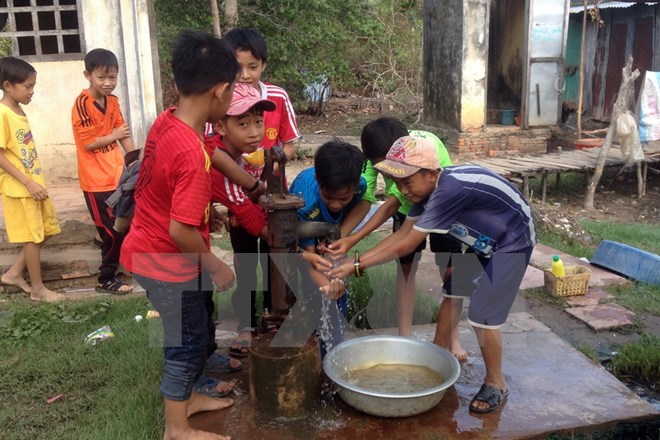 Niềm vui của trẻ em khi có nước sạch sinh hoạt. Ảnh: Lê Sen/TTXVN