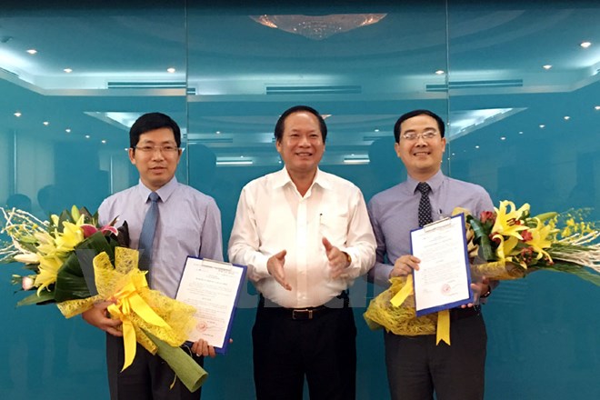 Bộ trưởng Trương Minh Tuấn (giữa) trao quyết định cho ông Lưu Đình Phúc (trái) và ông Đinh Tiến Dũng (phải). Ảnh: CTV/Vietnam+