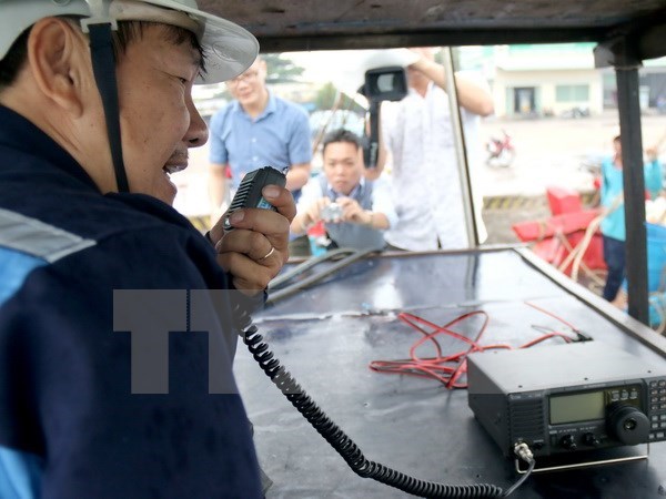Kiểm tra thiết bị thông tin liên lạc lắp trên tàu cho ngư dân. Ảnh: Nguyễn Thanh/TTXVN