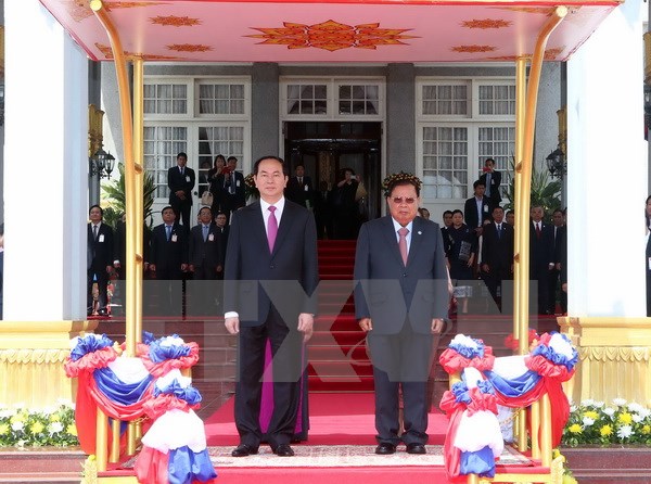  Chủ tịch nước Trần Đại Quang và Tổng Bí thư, Chủ tịch nước Lào Bounnhang Volachith trên bục danh dự. Ảnh: Nhan Sáng/TTXVN