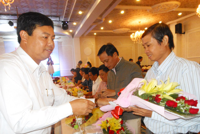 Ông Nguyễn Tiến Hải, Chủ tịch UBND tỉnh Cà Mau (trái) trao hoa mừng ngày Nhà báo Việt Nam 21/6