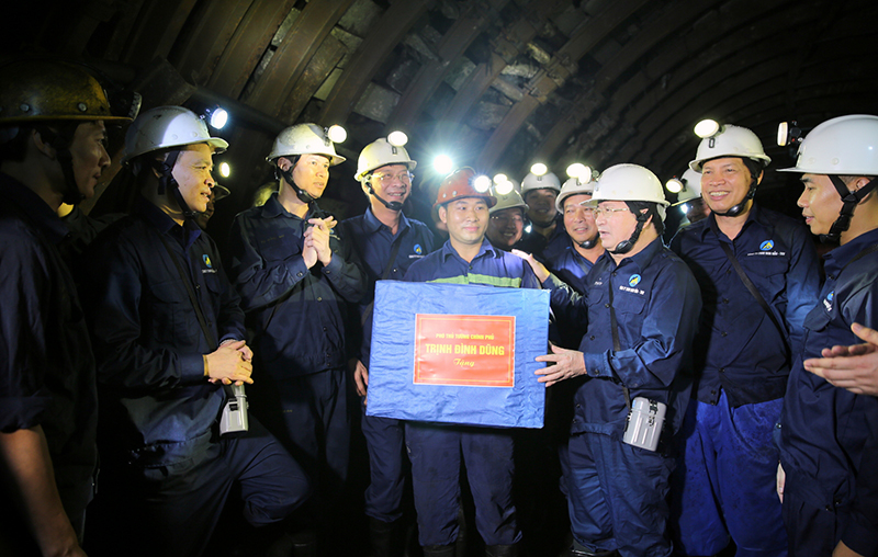 Phó Thủ tướng Trịnh Đình Dũng động viên, tặng quà công nhân đang khai thác trong hầm lò. Ảnh: VGP/Xuân Tuyến