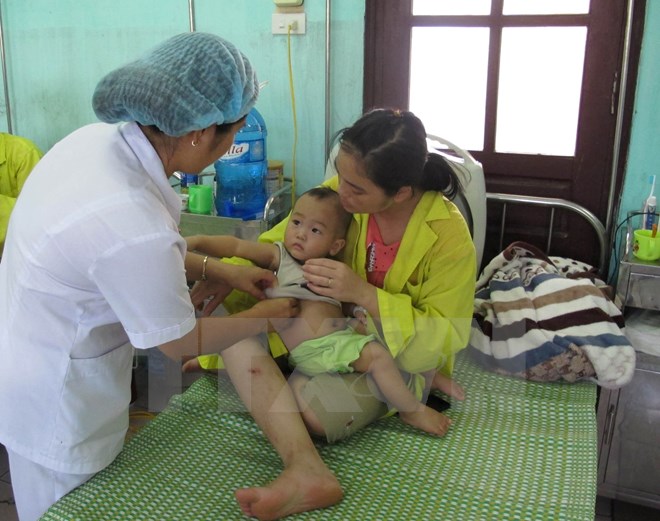 Nhân viên y tế chăm sóc cho bệnh nhi. Ảnh: TTXVN/Vietnam+