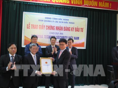Chủ tịch UBND tỉnh Bắc Ninh trao giấy chứng nhận đầu tư 100 triệu USD cho đại diện Công ty Hanwha Techwin Security Hàn Quốc.Ảnh: Thái Hùng - TTXVN