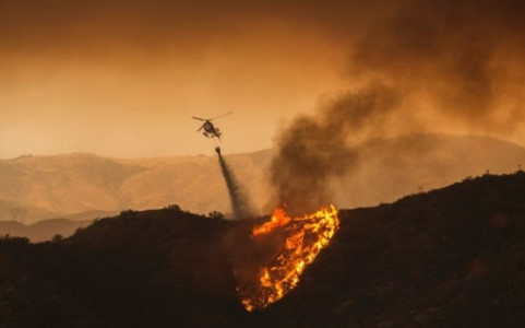 Máy bay trực thăng thả nước dập tắt các đám cháy tại Santa Clarita. Ảnh AFP