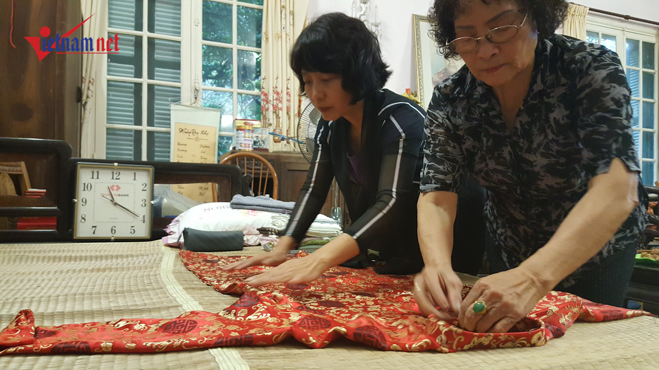 Bà Hà và bà Yến, hai người con dâu của cụ Hoàng Thị Minh Hồ đang xếp lại chiếc áo dài của mẹ. Ảnh: Diệu Bình