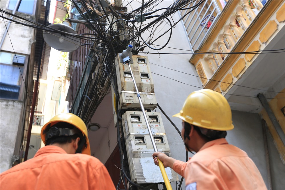 Công nhân đo chỉ số công-tơ điện của người dân trên phố Thái Hà. Ảnh: Hải Nguyễn