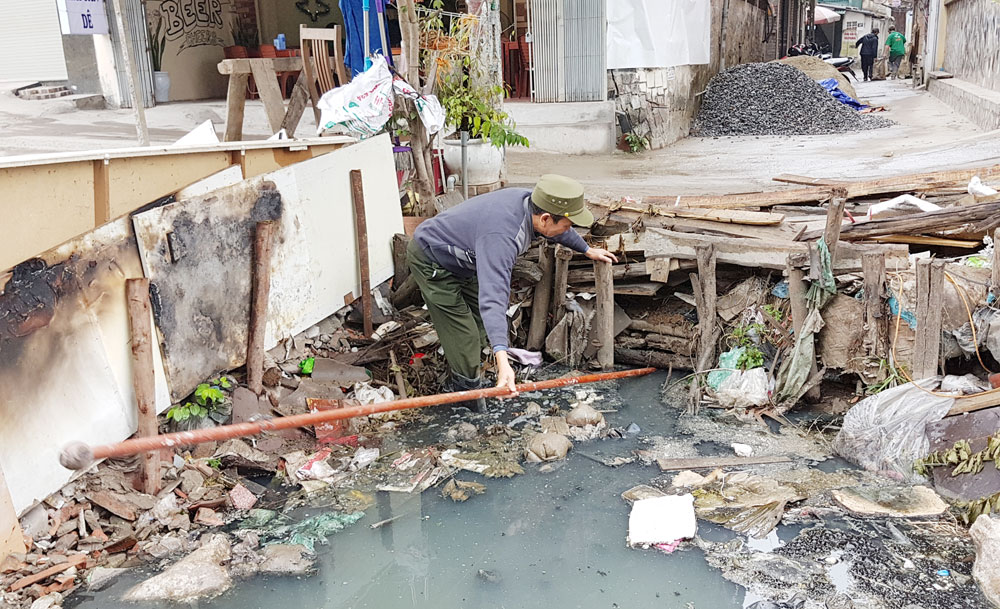 Do rác thải làm tắc cống thoát nước thải nên ông Hoàng Đình Thái, cụm dân cư số 6, phường Đội Cấn thường xuyên phải lội mương vớt rác