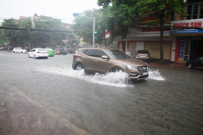 Mưa lớn khiến tuyến phố Nguyễn Công Trứ bị ngập sâu, gây khó khăn cho các phương tiện giao thông. (Ảnh: Phan Quân/TTXVN)