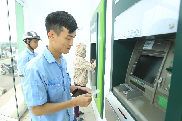  Người lao động rút tiền lương qua cây ATM tại Khu công nghiệp Thăng Long. Ảnh: Phạm Hùng