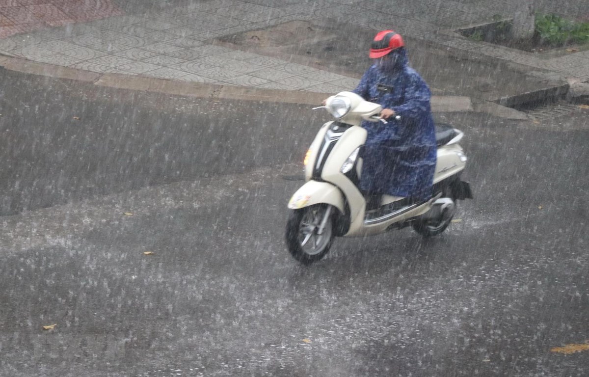Người dân đi lại dưới mưa lớn trên một con đường ở thành phố Đông Hà. (Ảnh: Nguyên Lý/TTXVN)