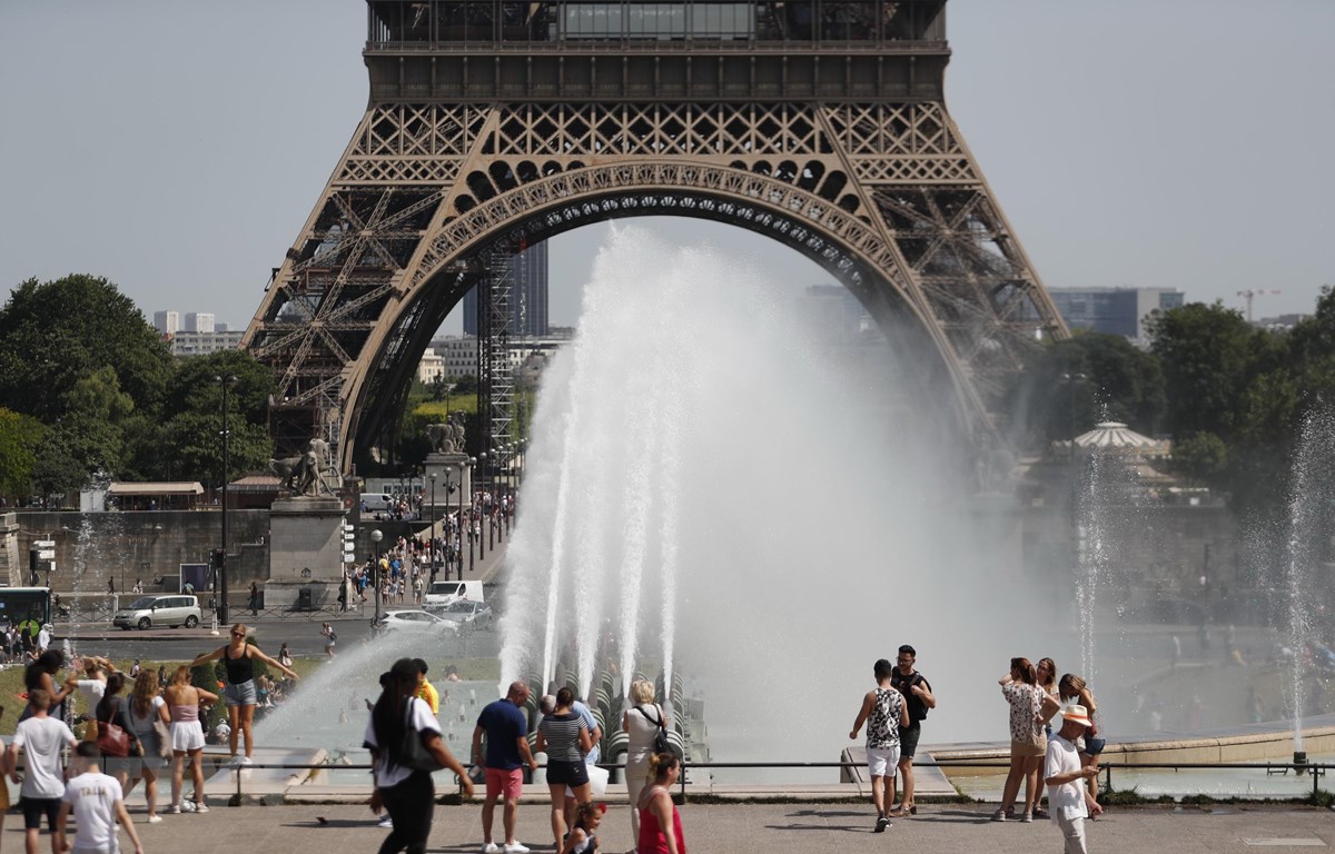 Người dân giải nhiệt tránh nóng tại một đài phun nước ở Paris, Pháp ngày 29/6/2019. (Ảnh: AFP/TTXVN)