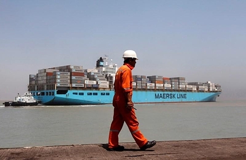  Một công nhân bước qua một tàu container phía xa tại Cảng Mundra, Gujarat, Ấn Độ. Ảnh: Reuters
