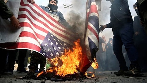  Người biểu tình tại Iran đốt cờ Mỹ và Anh sau khi tướng Qassem Soleimani bị giết. Ảnh: Reuters