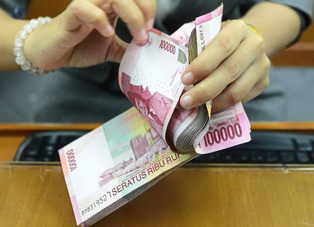 Một nhân viên đếm tiền giấy rupiah của Indonesia. Nguồn: Thestar