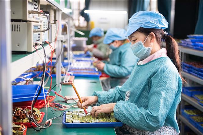  Công nhân kiểm tra linh kiện điện tử tại một nhà máy ở huyện Đào Viên, tỉnh Hồ Nam, Trung Quốc ngày 20/2/2020. Ảnh: THX/TTXVN