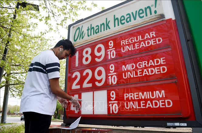 Nhân viên điều chỉnh bảng giá tại một trạm xăng ở Arlington, bang Virginia, Mỹ ngày 21/4. Ảnh: AFP/TTXVN