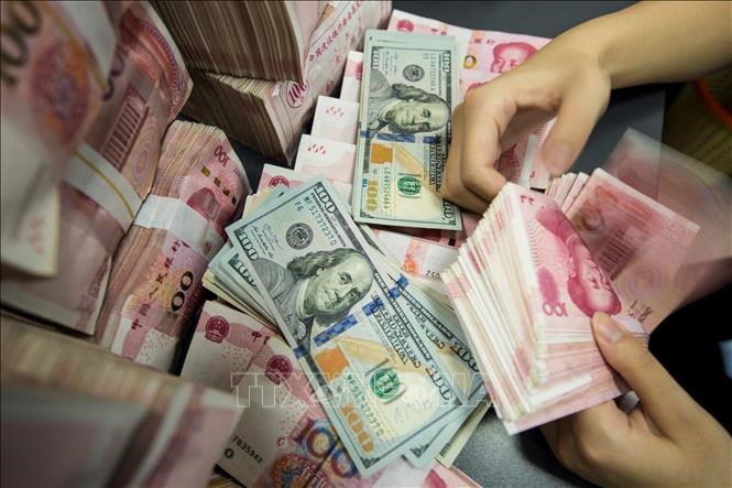 Kiểm đồng 100 NDT tại ngân hàng ở tỉnh Giang Tô, Trung Quốc. Ảnh: AFP/TTXVN