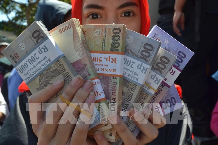Người dân kiểm đồng rupiah tại Malang, Indonesia. AFP/TTXVN