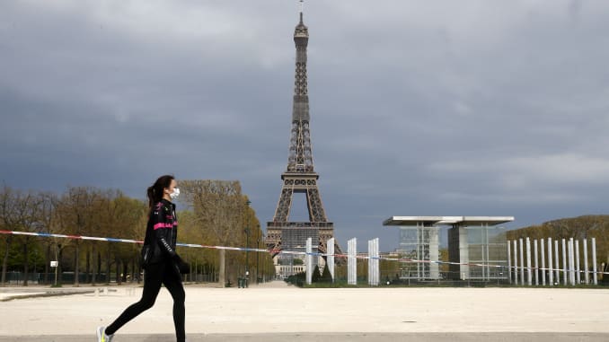   Một người dân đi ngang qua tháp Eiffel tại Paris, Pháp. Ảnh: CNBC