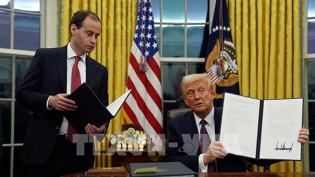 Tổng thống Mỹ Donald Trump (phải) ký sắc lệnh hành pháp. (Ảnh: AP/TTXVN)