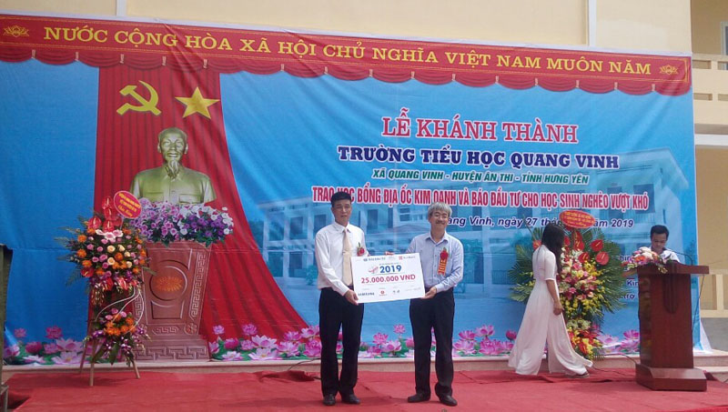 Phó Tổng biên tập Nguyễn Quốc Việt (bên phải) trao biển tượng trưng cho đại diện Trường Tiểu học Quang Vinh