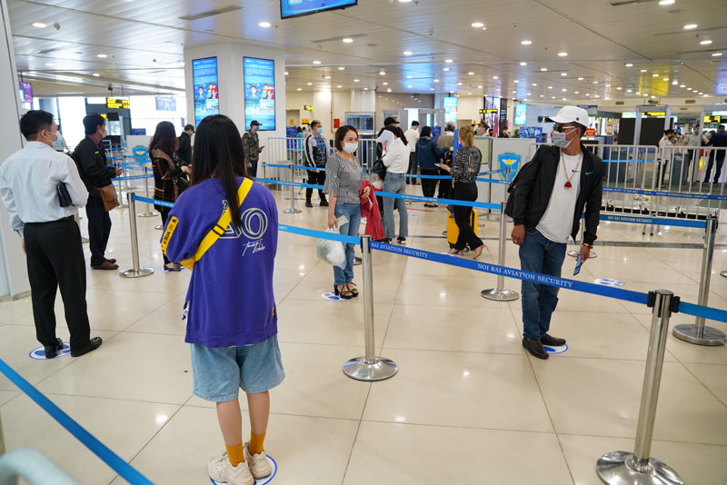 Hành khách tuân thủ quy định cách nhau 2 mét tại sân bay (Ảnh: VGP)