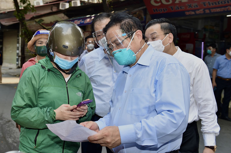 Thủ tướng kiểm tra giấy đi đường của người dân khi đi kiểm tra đột xuất công tác phòng chống dịch tại phường Thanh Xuân Trung ngày 31/8 (Ảnh: Nhật Bắc)