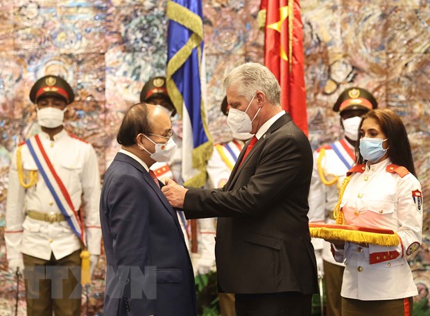 Chủ tịch Hội đồng Nhà nước và Hội đồng Bộ trưởng Cộng hòa Cuba Miguel Diaz Canel Bermudez gắn Huân chương Jose Marti cho Chủ tịch nước Nguyễn Xuân Phúc. (Ảnh: Vietnamplus.vn)
