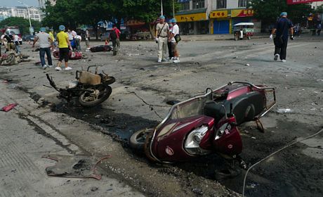 Một chiếc xe máy bị cháy rụi tại hiện trường (trái).