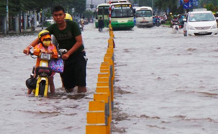 Một thợ sửa xe trên đường Kinh Dương Vương tiếp cận, hỗ trợ người đi đường bị chết máy