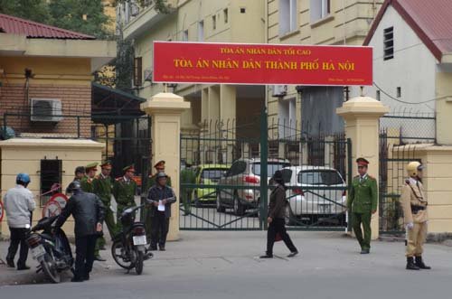 Cổng vào bên phải nơi xe chở bị cáo vào được canh gác và kiểm tra nghiêm ngặt.