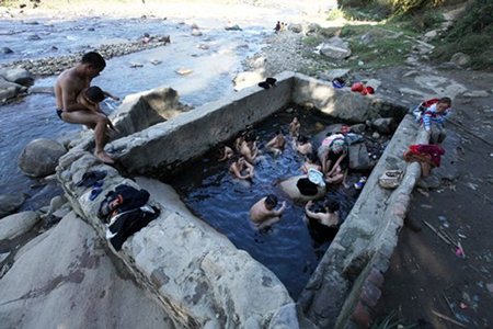 Mạch nước ngầm ấm nóng chảy ra suối được người dân ngăn lại, quây bể để làm nơi tắm.