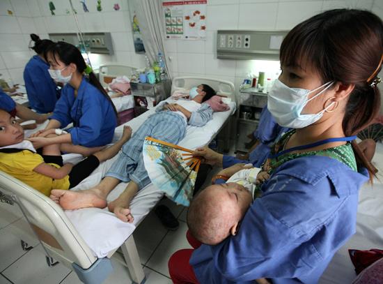 Tại Bệnh viện Nhiệt Đới, số lượng giường bệnh đã kín đặc, người lớn, trẻ em và trẻ sơ sinh nằm đan xen nhau