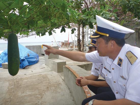 Chuẩn Đô đốc Đặng Minh Hải bên giàn bí tăng gia của chiến sĩ đảo Sinh Tồn Đông
