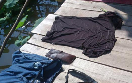 Một nạn nhân lỡ rớt xuống hồ sen khi chụp ảnh, ngậm ngùi phơi trang phục tại hồ sen.