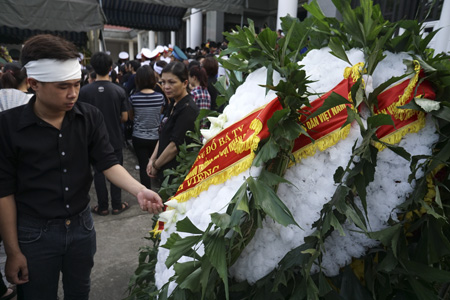 Người nhà của chiến sĩ Nguyễn Văn Thanh bên những vòng hoa trắng.