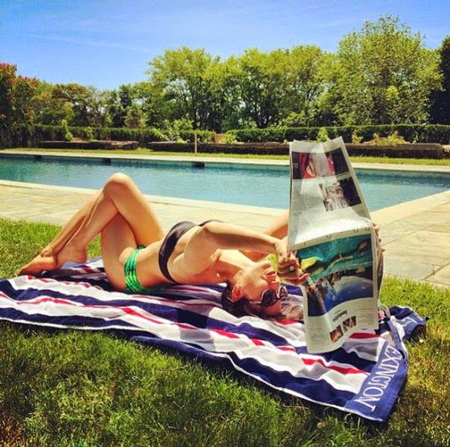 Người đẹp 30 tuổi đọc báo và sưởi nắng theo phong cách riêng.